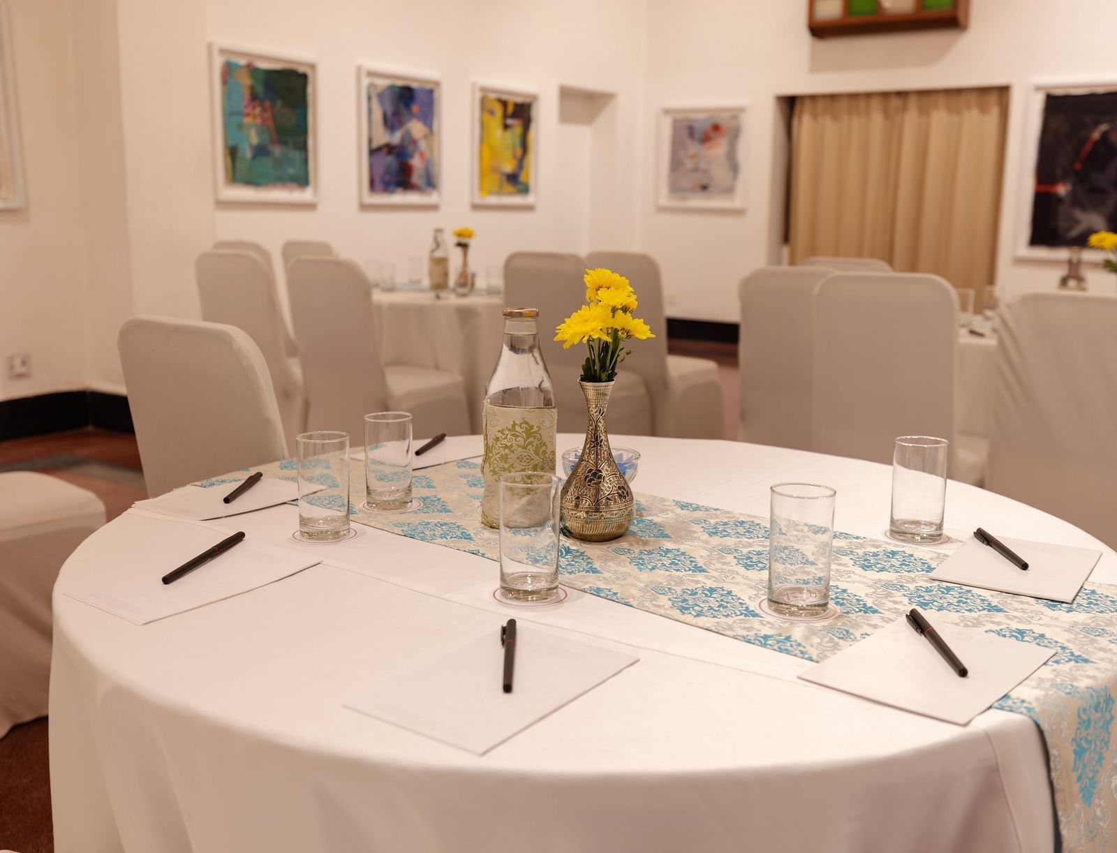 A round table placed in a banquet hall at Saraca Hotel, Lucknow with multiple chairs placed around it