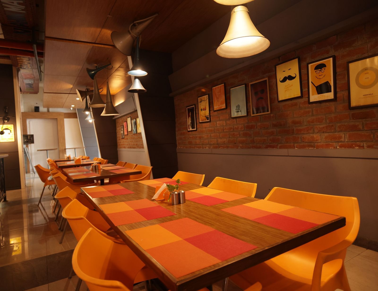 corner view image of the dining area with a warm ceiling light hanging over the table - Max Hotel, Jabalpur
