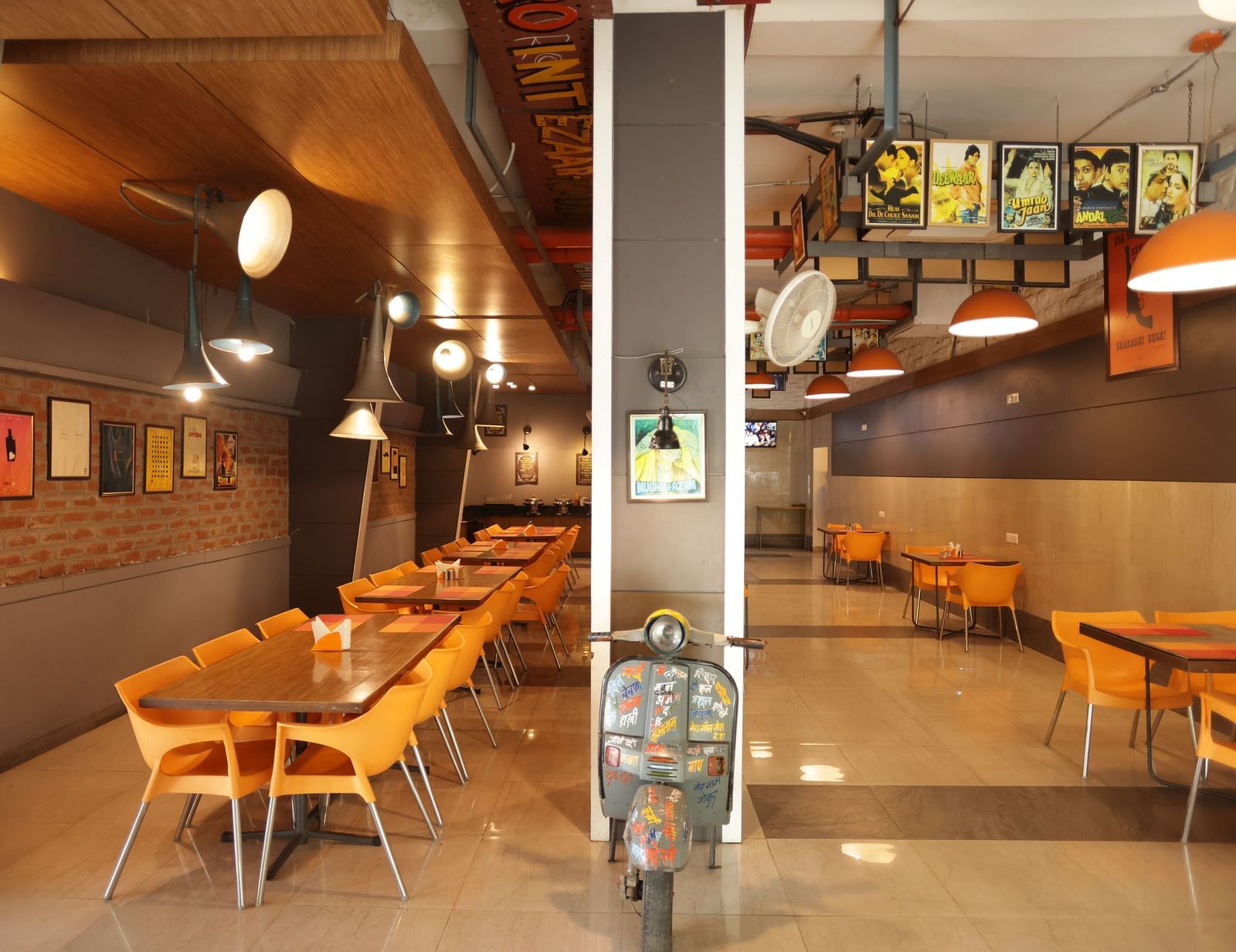 front view image of the dining area with a decorative vintage two wheeler kept in the entrance - Max Hotel, Jabalpur