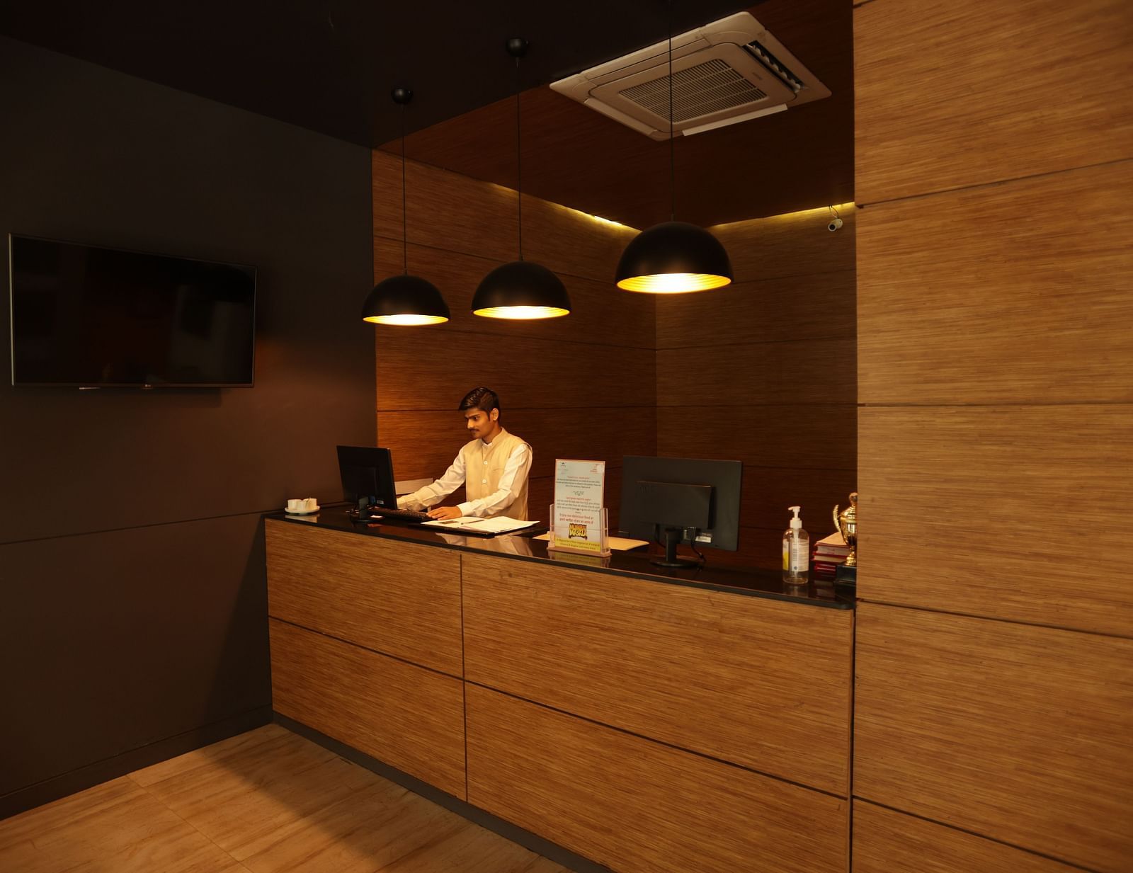 the billing area with a person standing behind the counter looking into his system - Max Hotel, Jabalpur