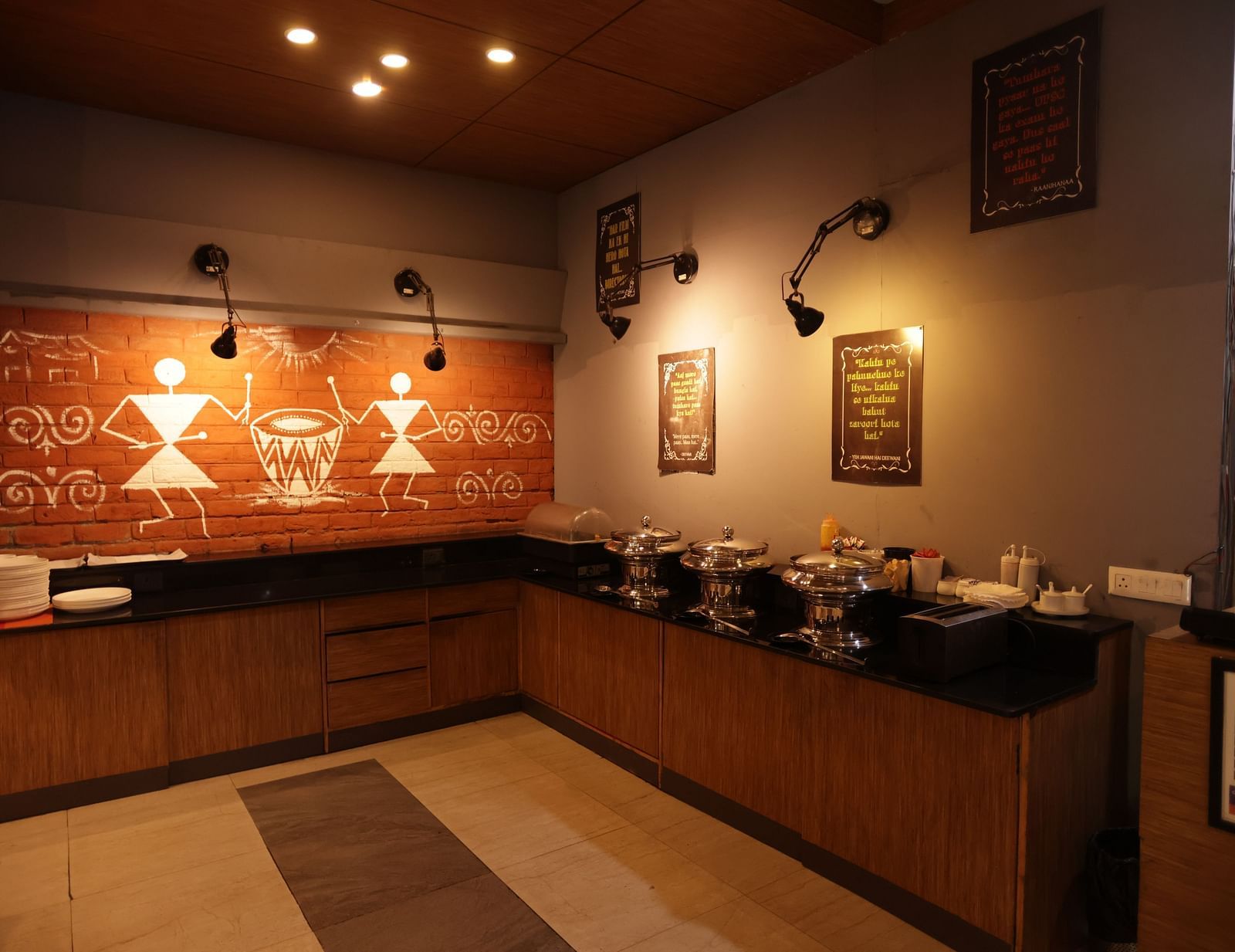 a buffet area in the corner of the restaurant with wall hanging decorative pieces - Max Hotel, Jabalpur