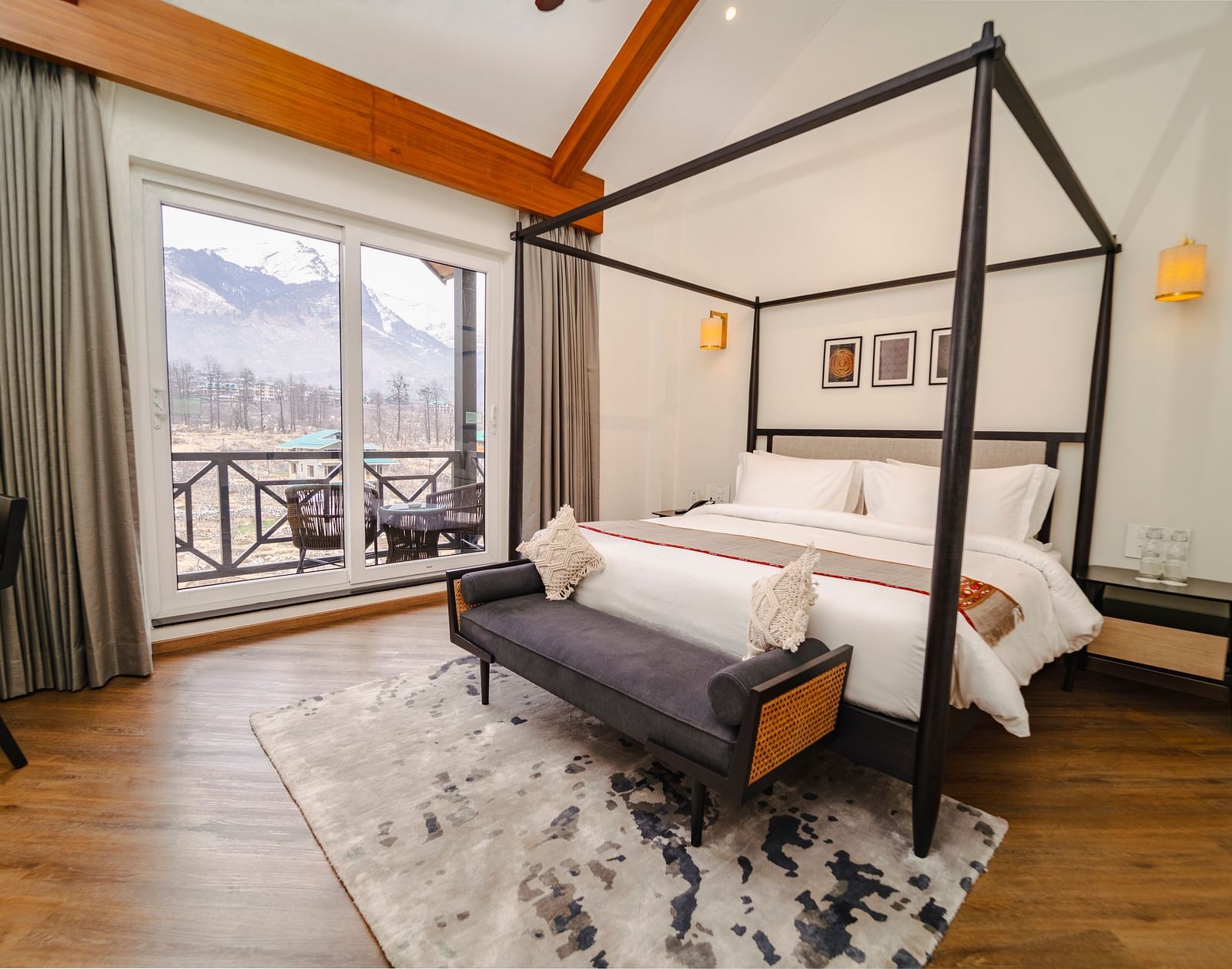 Bedroom with a four-poster bed, balcony, and mountain view at Nivasana Manali.