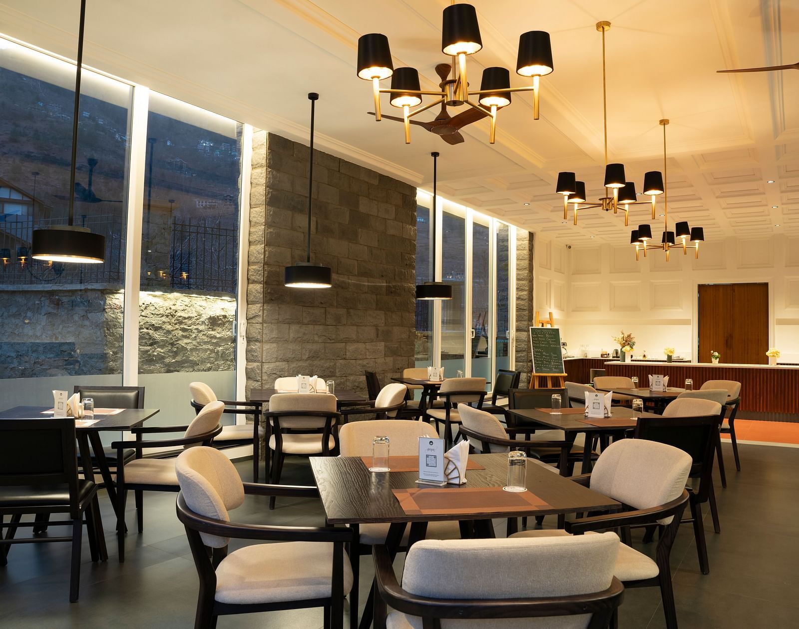 Modern dining space with pendant lighting and soft tones at Nivasana Manali.