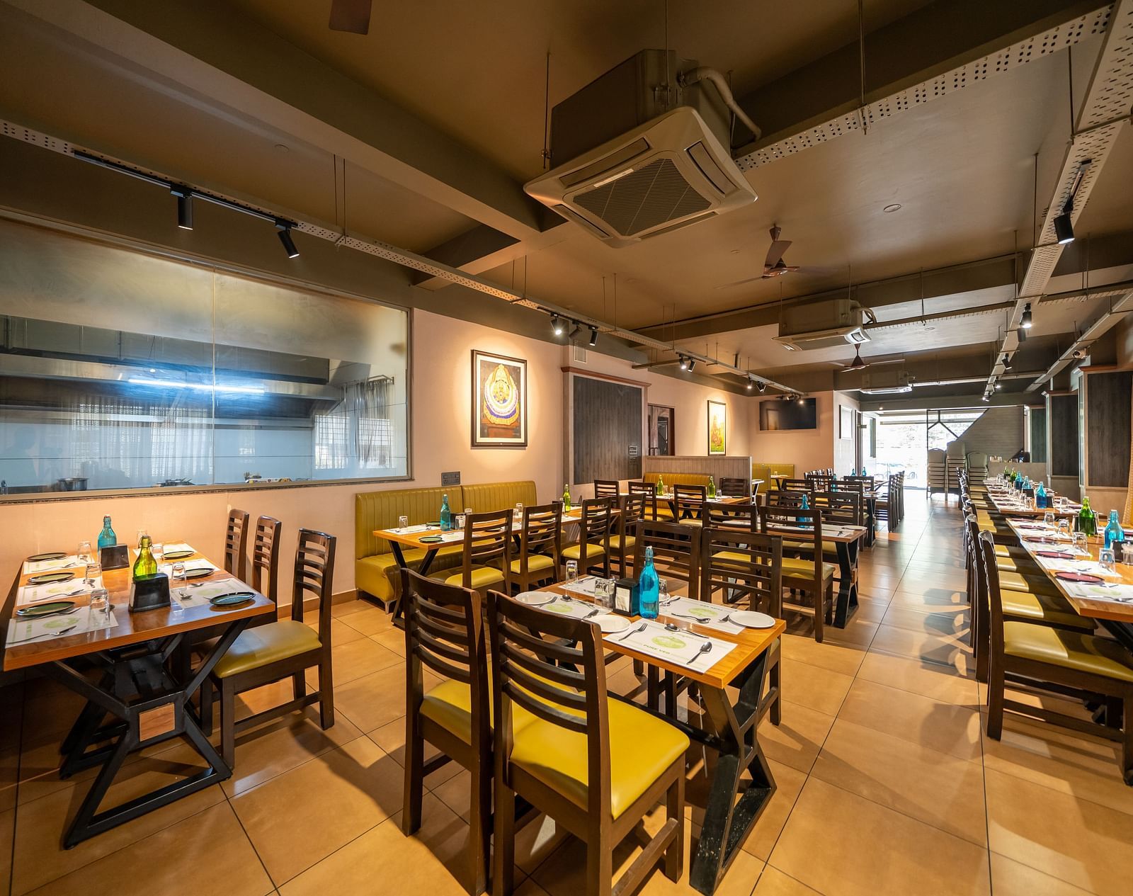 Image of a dining area with tables and chairs arranged around it at Hari Govindas, Siddappa Square.