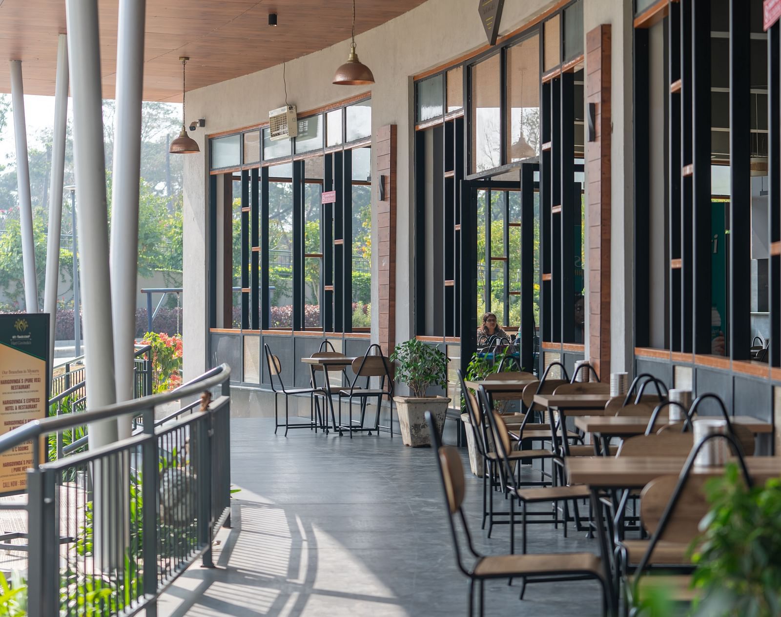 Outdoor dining area at Hari Govinda's, where tables and chairs are set beside the wall