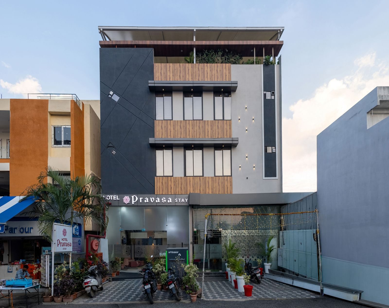 The facade of a modern multi-storey Pravasa Stay Dewas Naka, Indore under the blue sky.