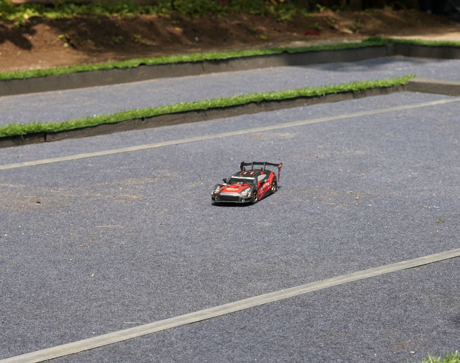 A remote-controlled drift car racing on an outdoor track at RD’s Nature Retreat.