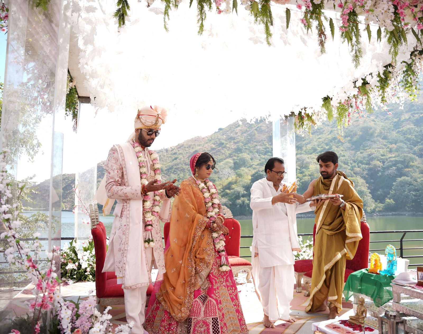 Bride and groom in traditional attire, walking with family - Via Lakhela Resort & Spa