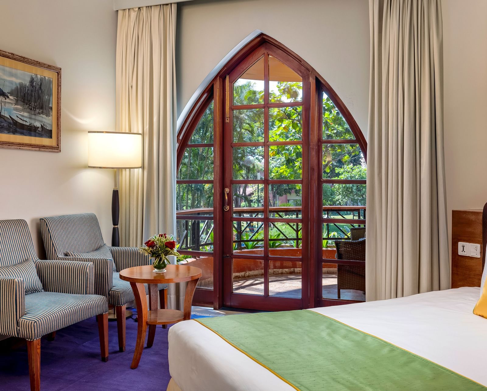 a double bed, sofas, and a table inside Superior Room - Caravela Beach Resort Goa