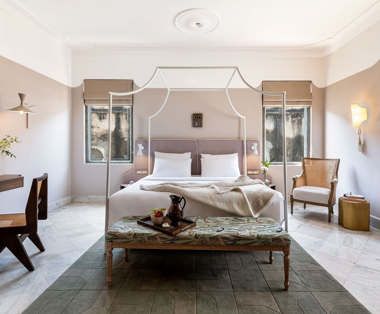 a double bed with a small seating area at the base of the bed inside one of the rooms - Manuscript - Jhilwara Haveli, Udaipur