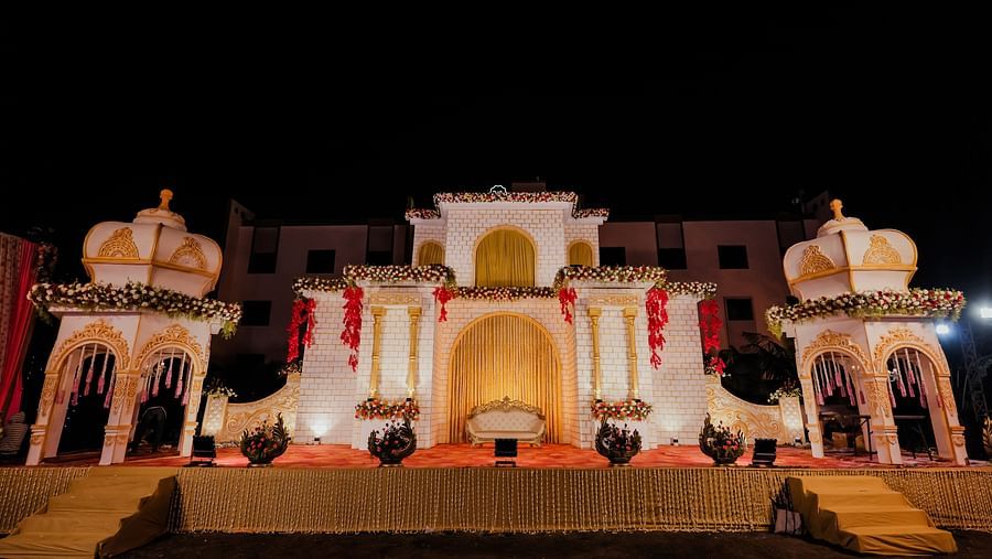 A podium adorned with castle-like structures stands against a backdrop, creating a regal setting for what appears to be a wedding. - Wedlock Greens Hotel Resorts Dhanbad