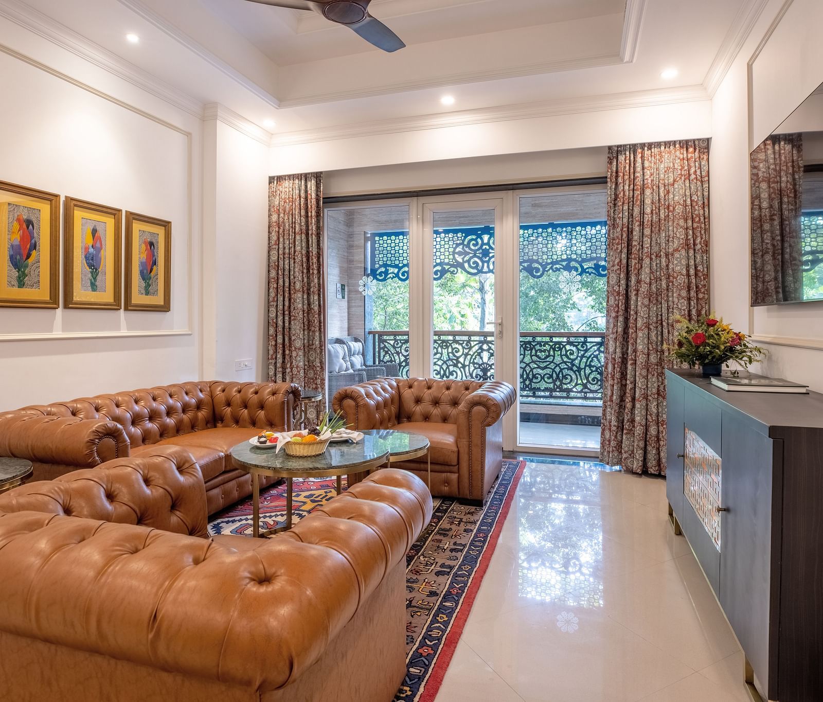 A luxury living area with a sofa set, large glass windows, and a wall-mounted TV at MAYFAIR Palm Beach Resort, Gopalpur-On-Sea
