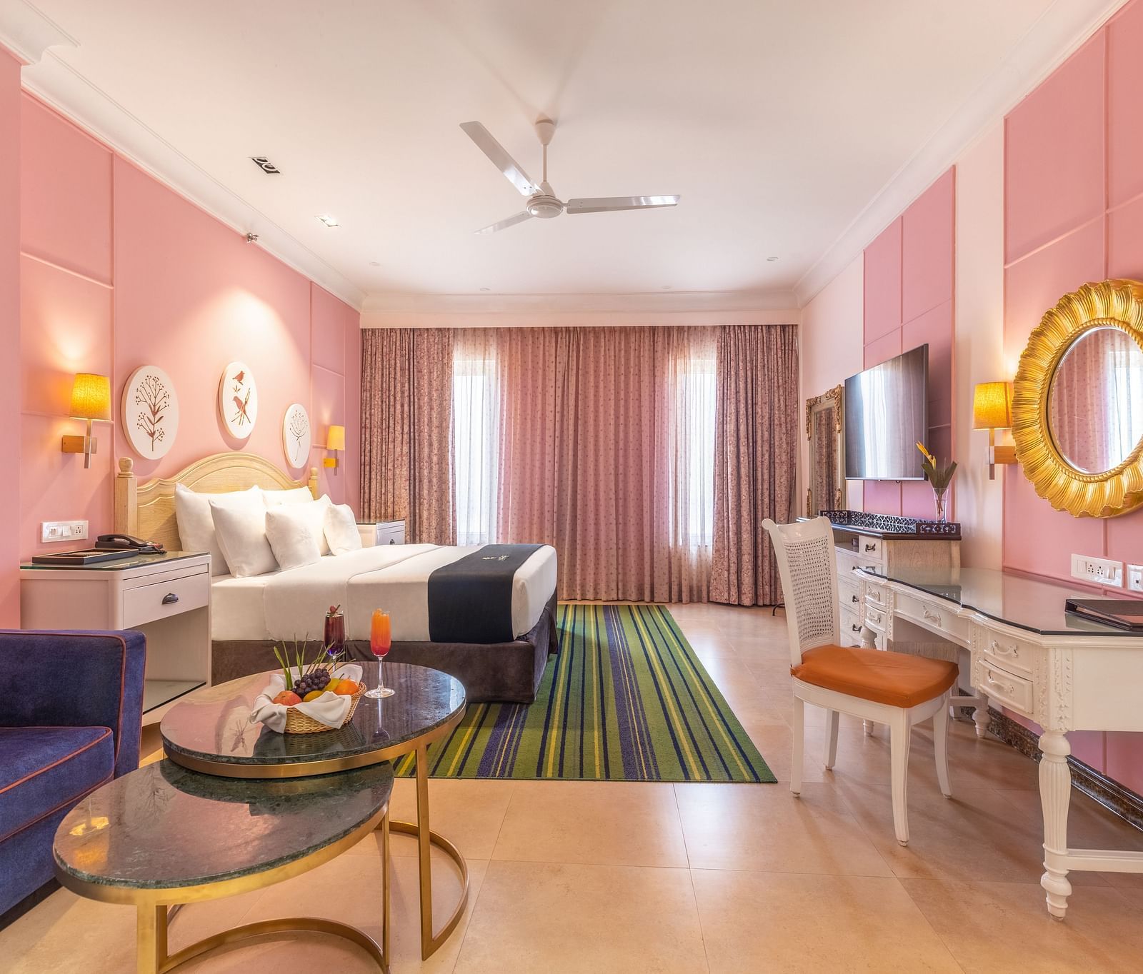 Double bed room with a lounge area, a workstation, large glass windows, and a wall-mounted TV at MAYFAIR Palm Beach Resort, Gopalpur-On-Sea