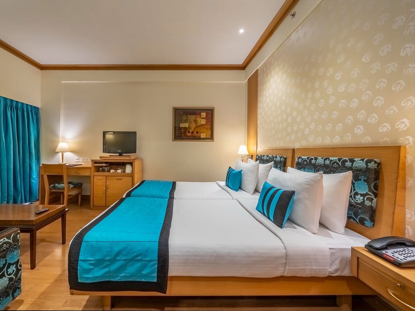 side view of beds with white and blue linen in the Executive Room at Kenilworth Hotel, Kolkata