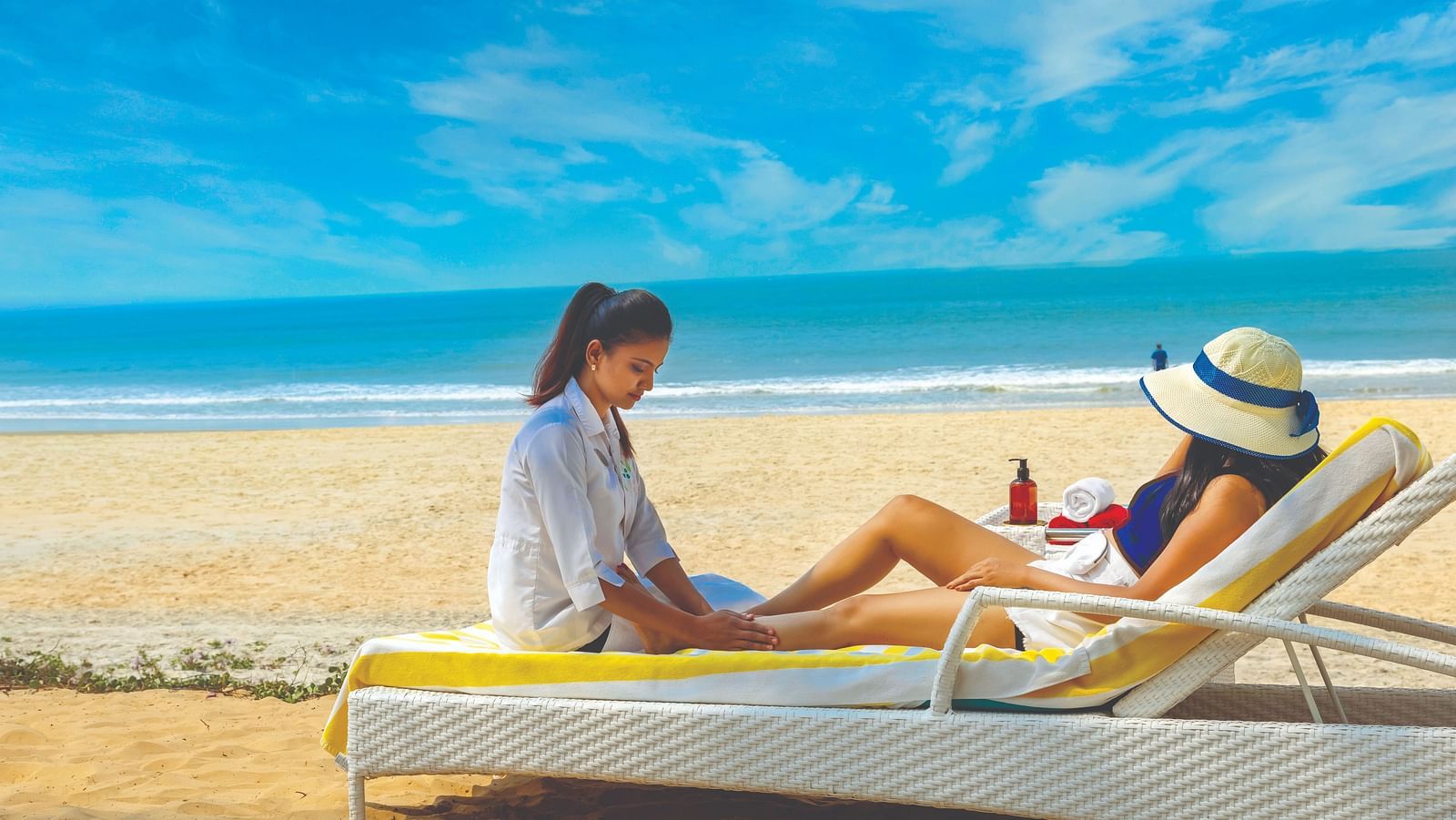  two women sitting on the lounger on the beach - Caravela Beach Resort Goa