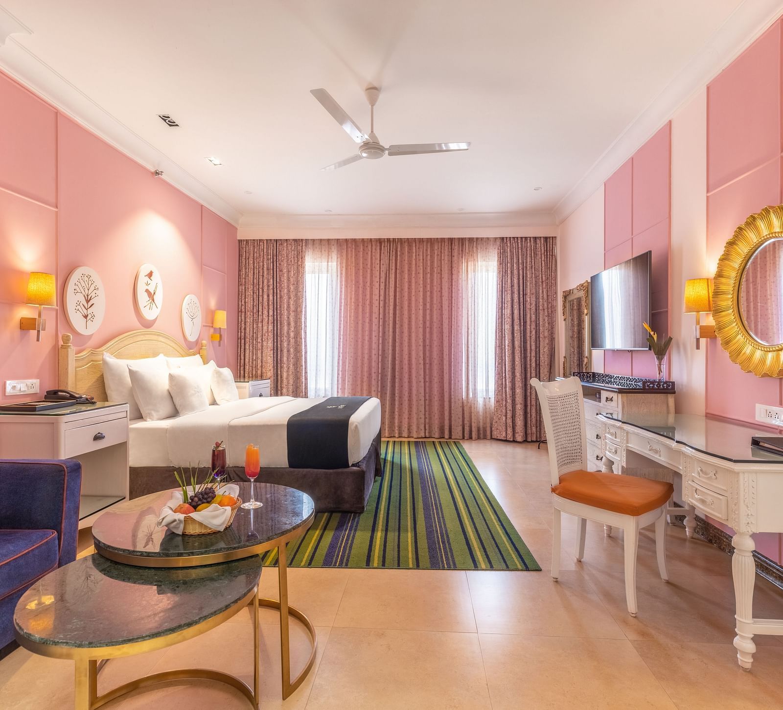 Double bed room with a lounge area, a workstation, large glass windows, and a wall-mounted TV at MAYFAIR Palm Beach Resort, Gopalpur-On-Sea