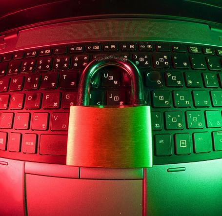 A neon-lit laptop secured with a padlock, symbolizing digital safety