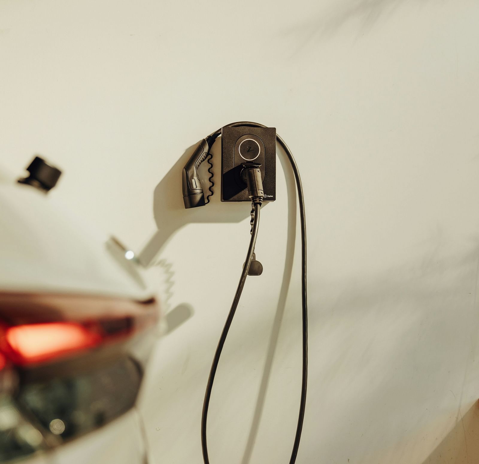 an image of a car charger wall mounted with the back of a car in view