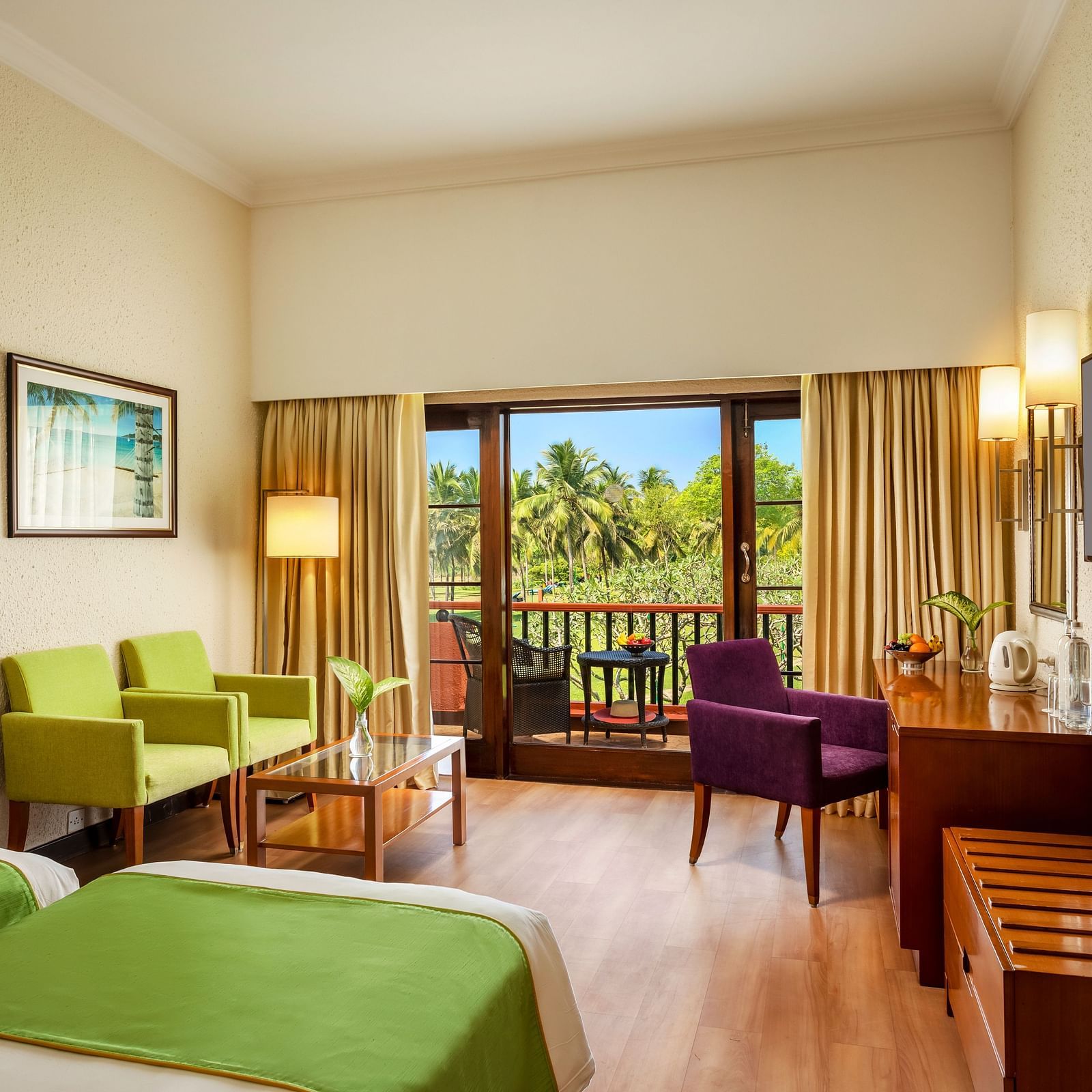 twin beds with sofas, lamps and a tv inside Garden View Room - Caravela Beach Resort Goa