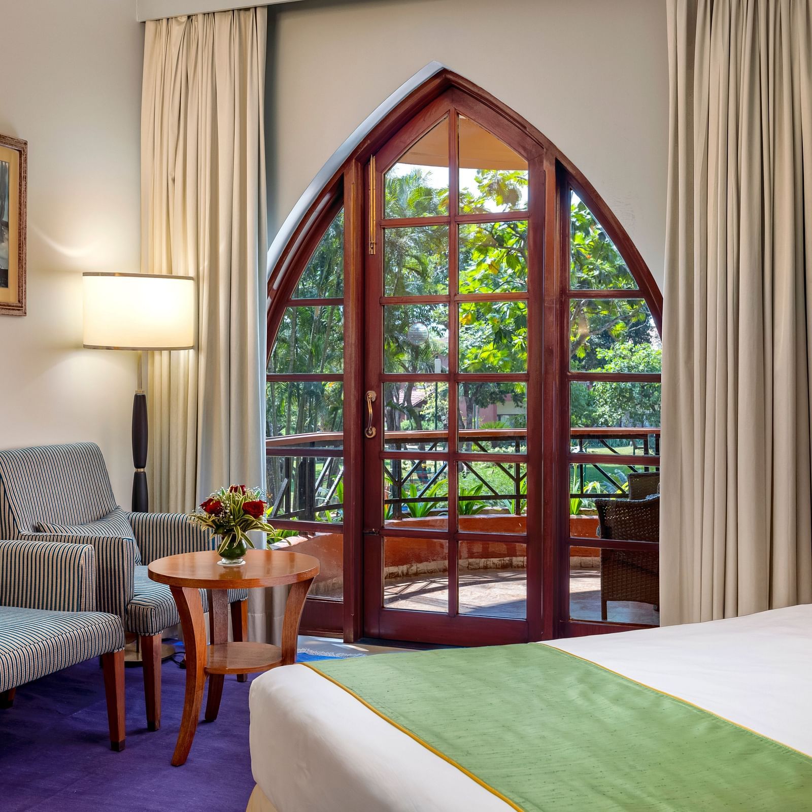 a double bed, sofas, and a table inside Superior Room - Caravela Beach Resort Goa