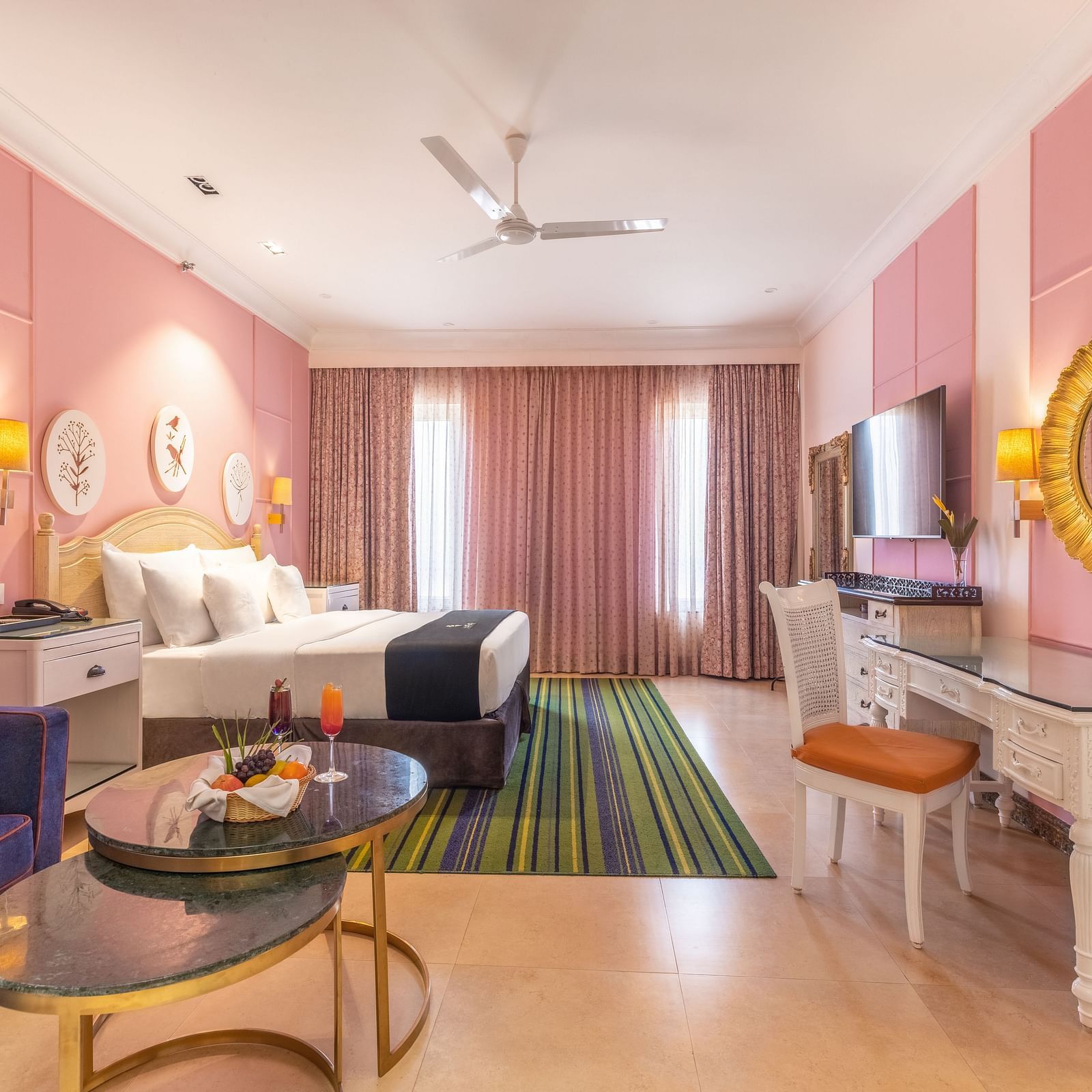 Double bed room with a lounge area, a workstation, large glass windows, and a wall-mounted TV at MAYFAIR Palm Beach Resort, Gopalpur-On-Sea