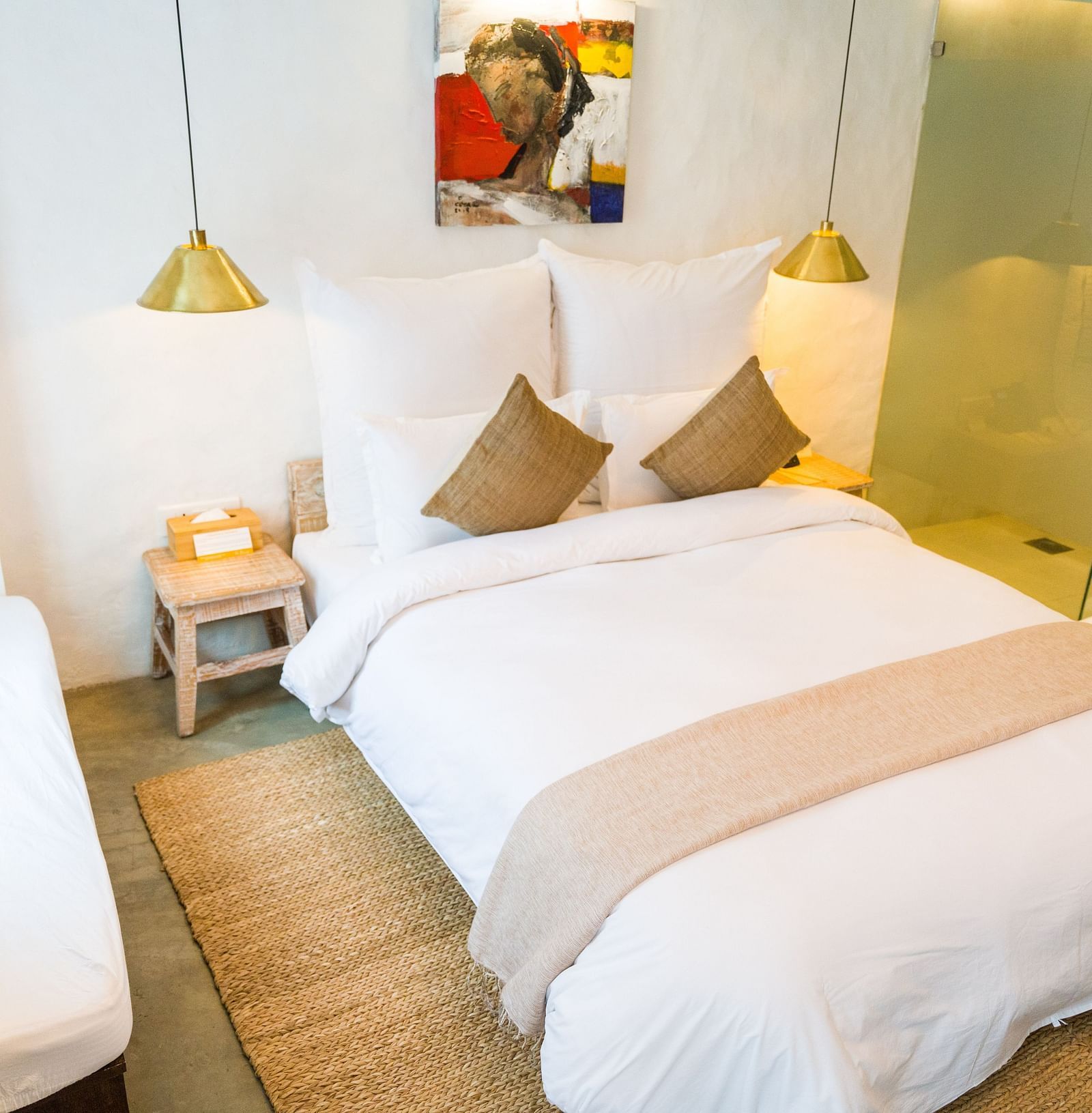 Deluxe loft room with a double bed, and a single bed side tables, and lamps hanging from the ceiling - The Nanee