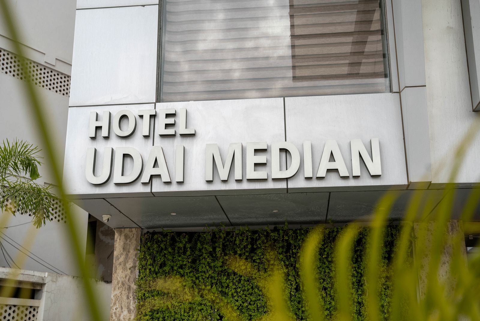 Facade shot of Hotel Udai Median, Udaipur with greenery in the front.