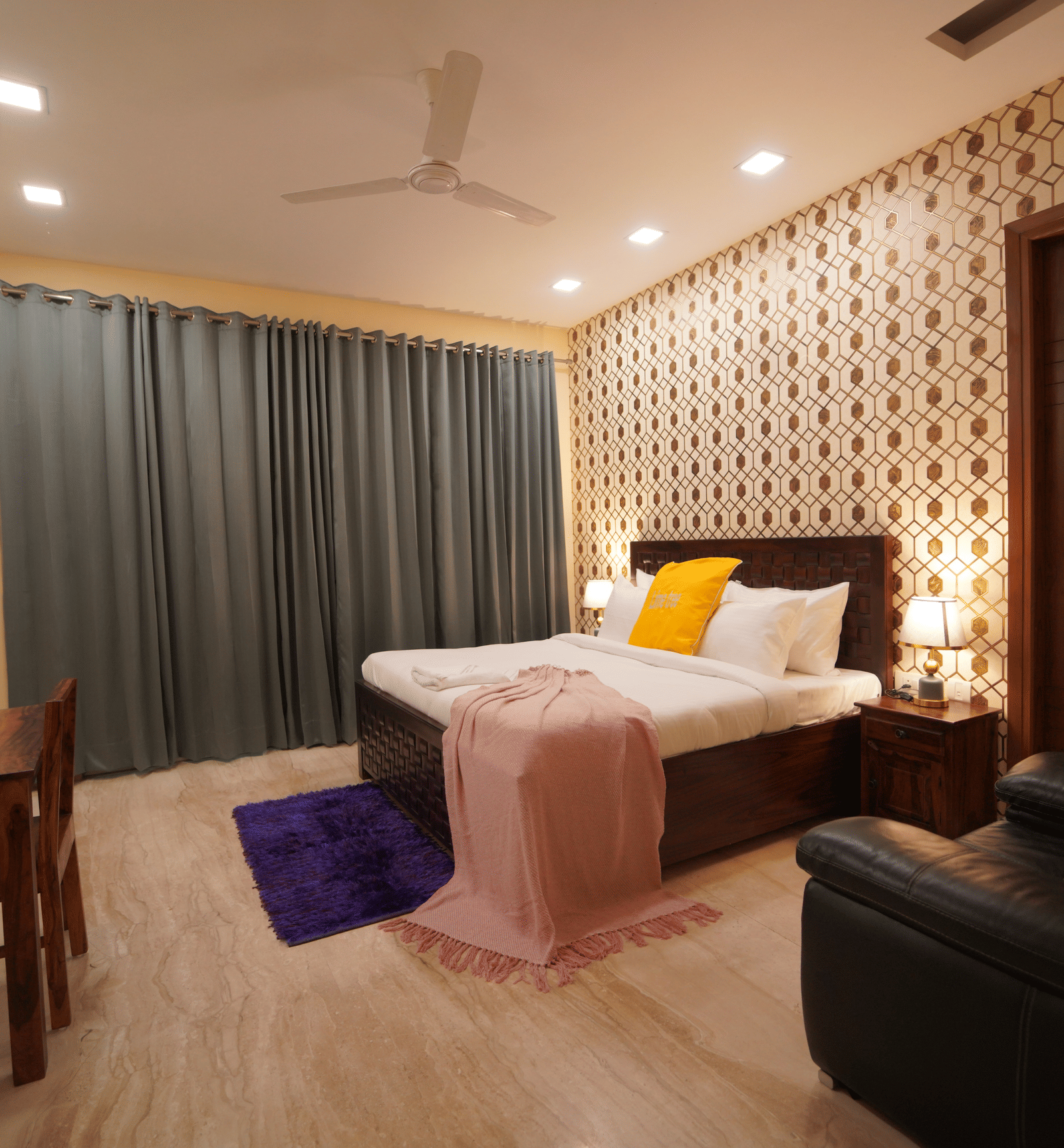 An image of a bedroom featuring a double size bed, a  sofa. a flat TV screen, and a work desk and chair - Lime 3BHK Serviced Apartments, DLF Phase -5 Gurgaon
