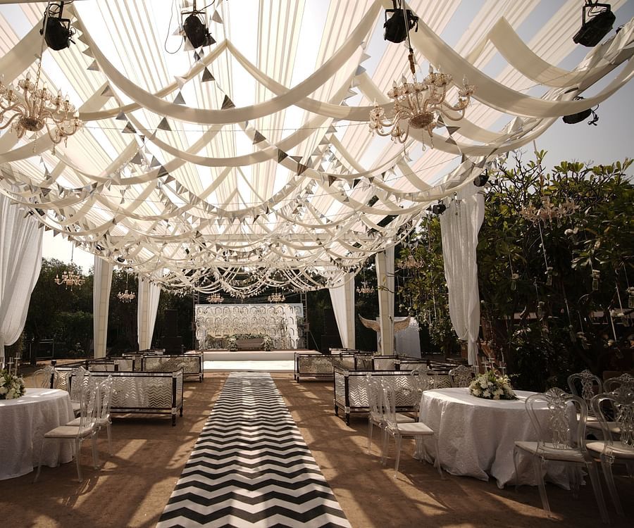 a decorated walkway to the stage with seating arrangements on the side - heritage village resorts & spa, Manesar