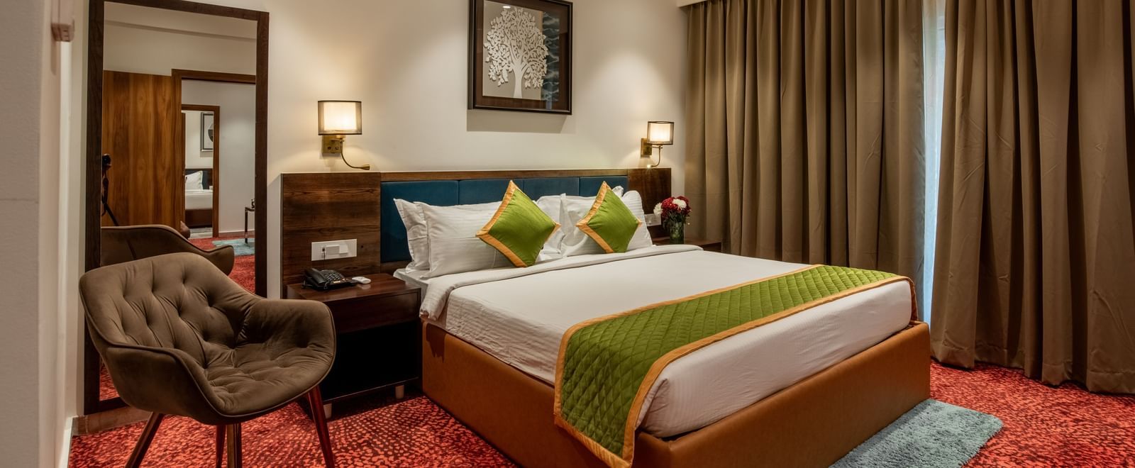 Spacious guest room with king size bed and seating area at Hotel Royal Regency Chennai