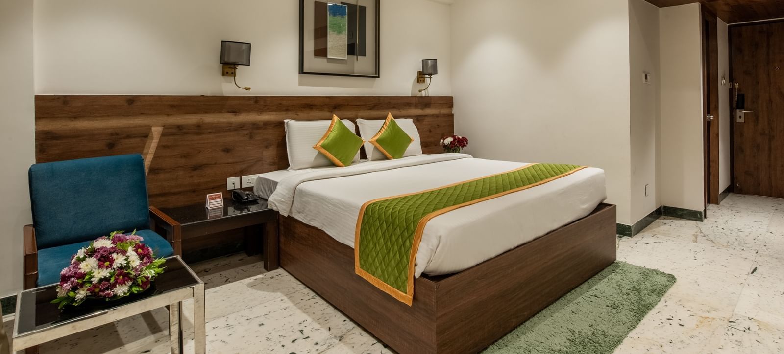 Spacious room with double bed, chairs, and bedside lamps at Hotel Royal Regency Chennai