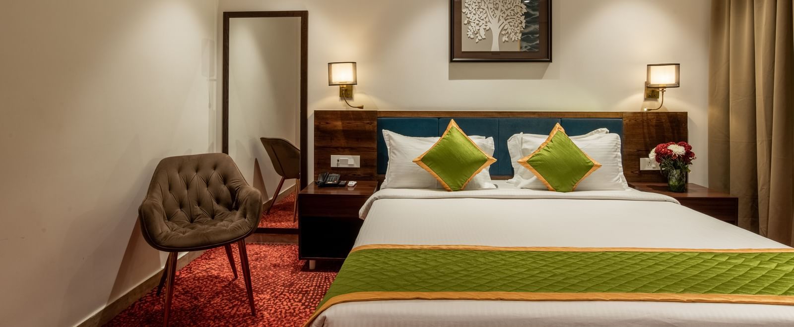 Bedroom with king size bed, wooden furniture, and warm lighting at Hotel Royal Regency Chennai