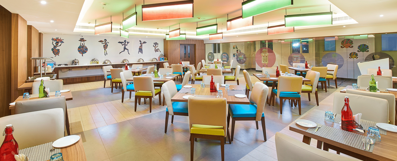 The warmly lit dining area has seats and tables set and ready for guests