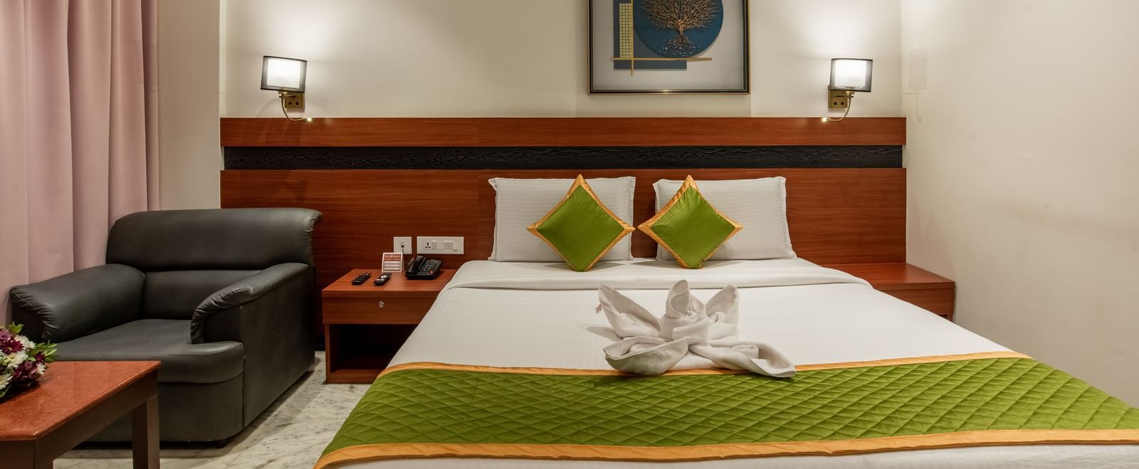 Spacious bedroom with king size bed, seating area, and elegant lighting at Hotel Royal Regency Chennai