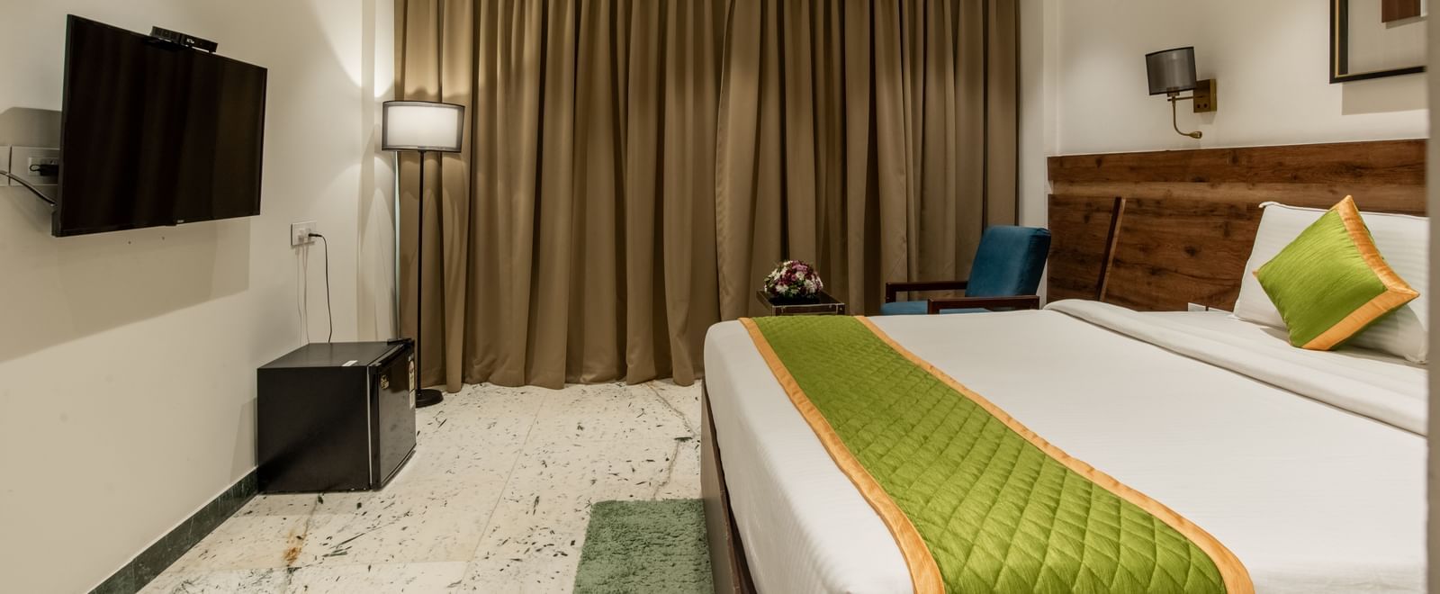 Modern room with bed, armchair, and bedside lamps at Hotel Royal Regency Chennai