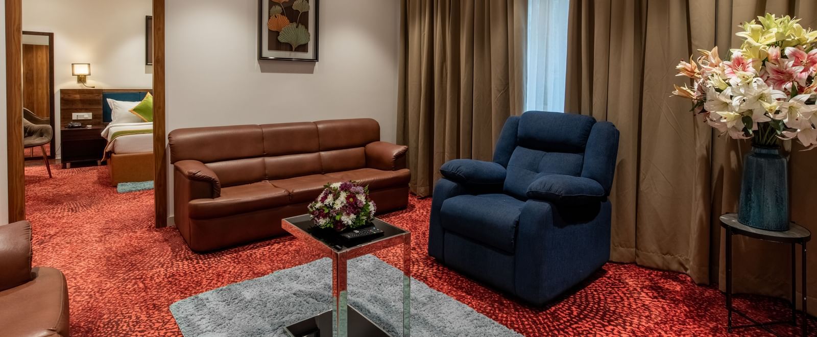 Living room with sofa set, armchair, and coffee table at Hotel Royal Regency Chennai