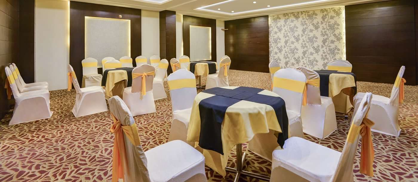 A shot of white table and chairs arranged for an event t the banquet hall.