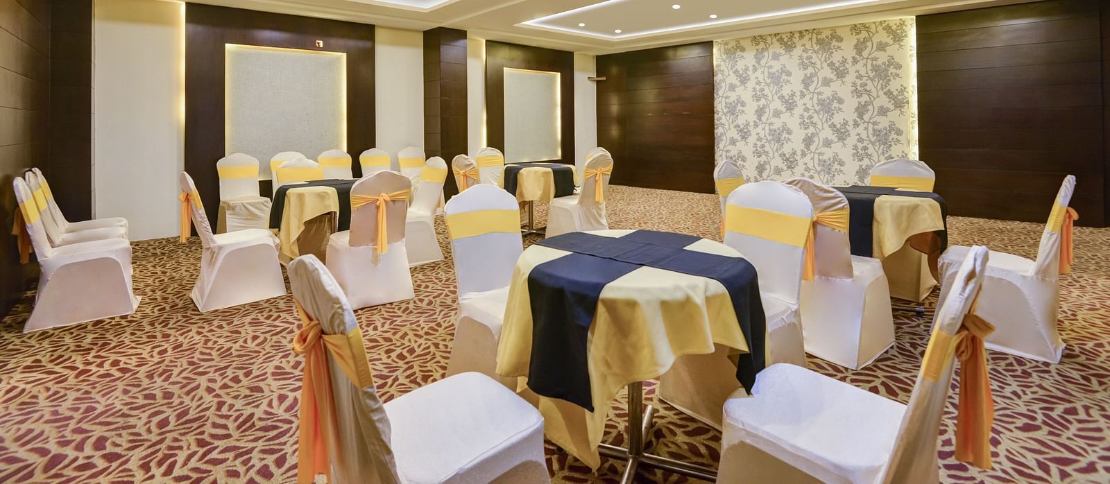A shot of white table and chairs arranged for an event t the banquet hall.