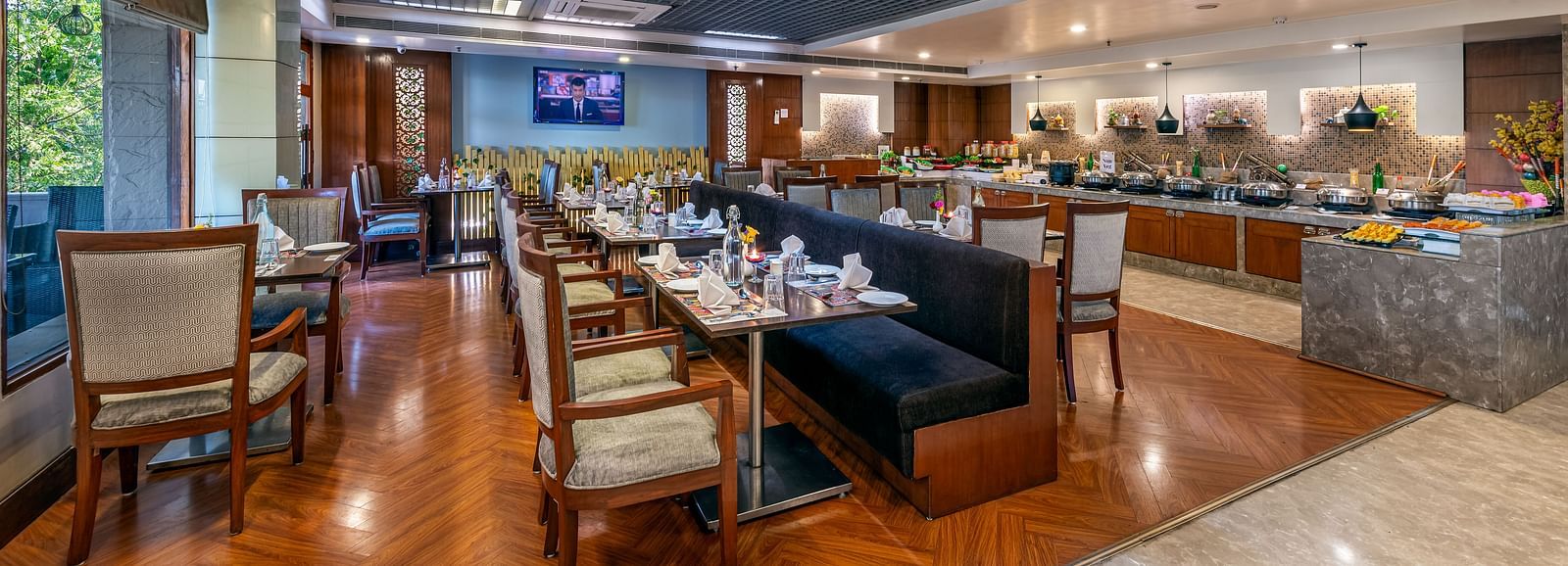 Spacious dining area with multiple tables and decorative ceiling at Lords Plaza Jaipur.