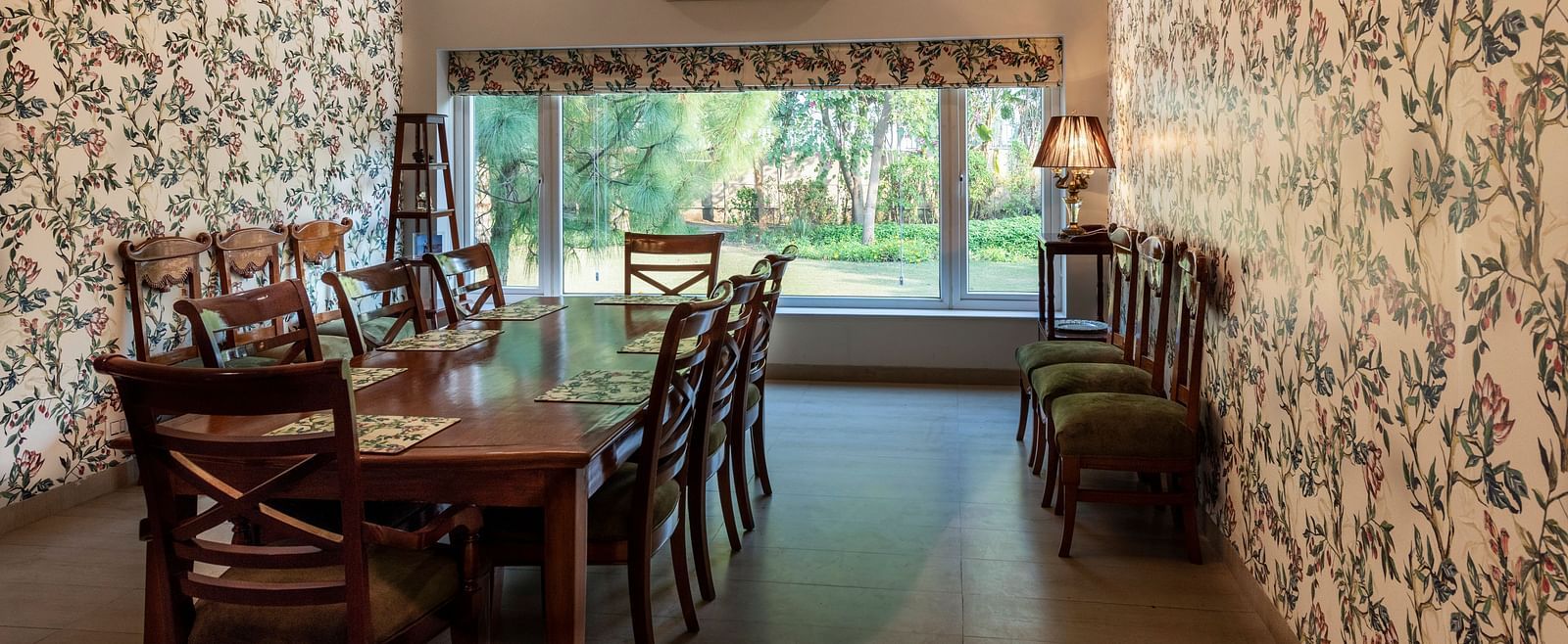 An image of a dining room with floral walls, a chandelier and an AC in the background.