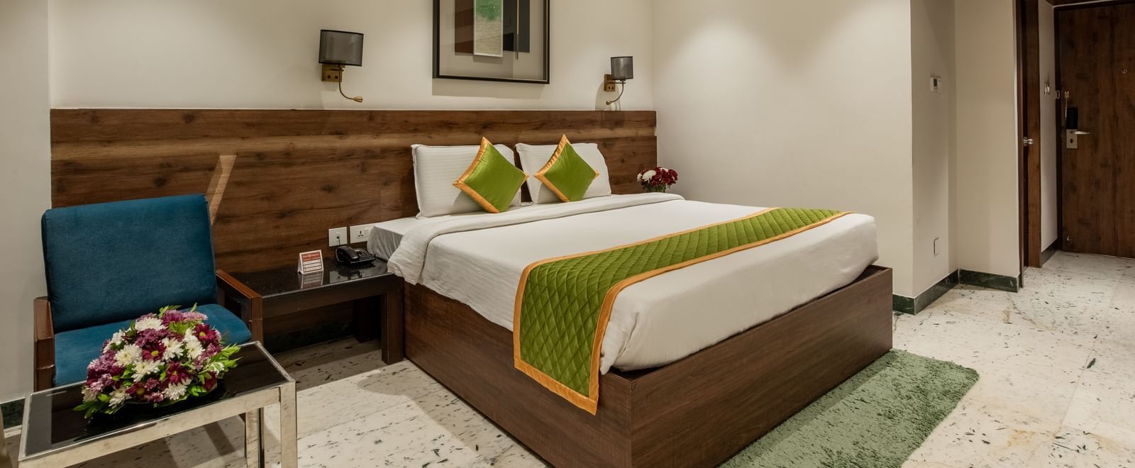 Spacious room with double bed, chairs, and bedside lamps at Hotel Royal Regency Chennai