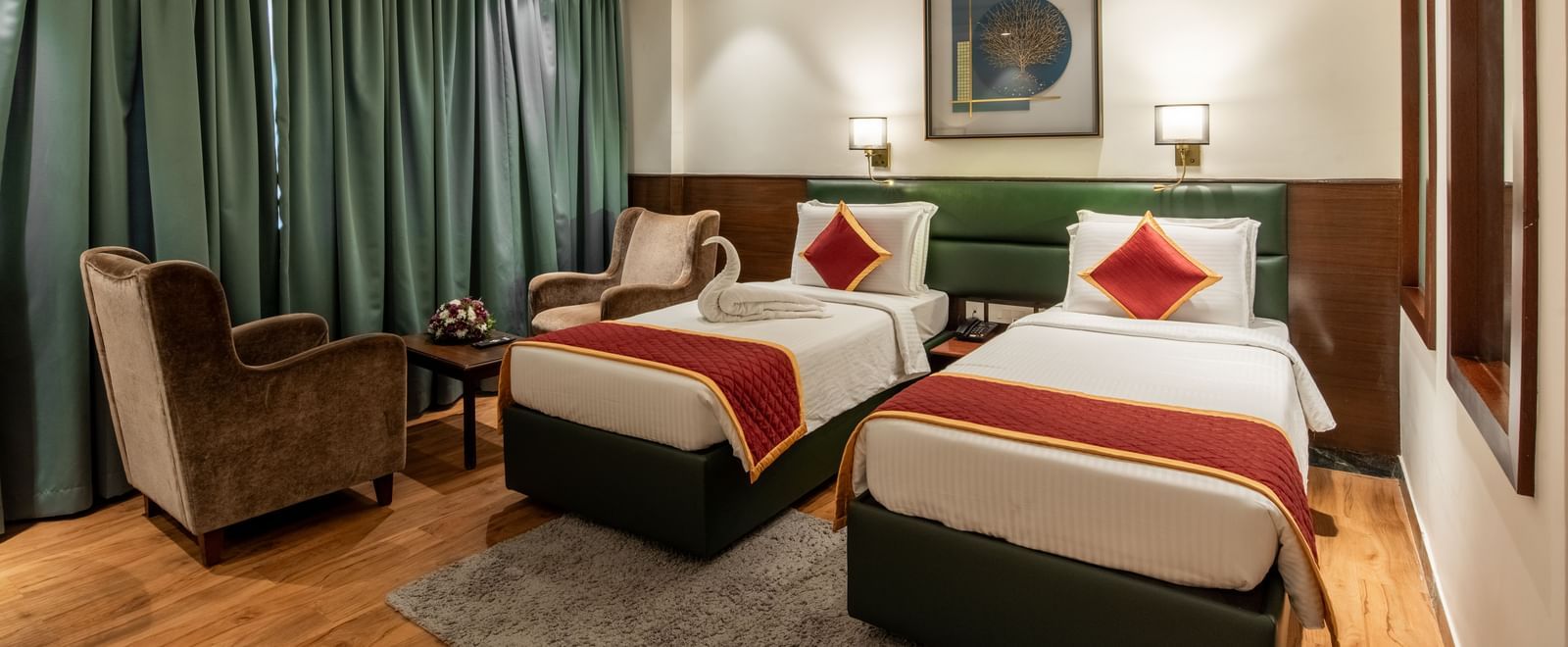 Spacious twin bedroom with comfortable seating and decor at Hotel Royal Regency 