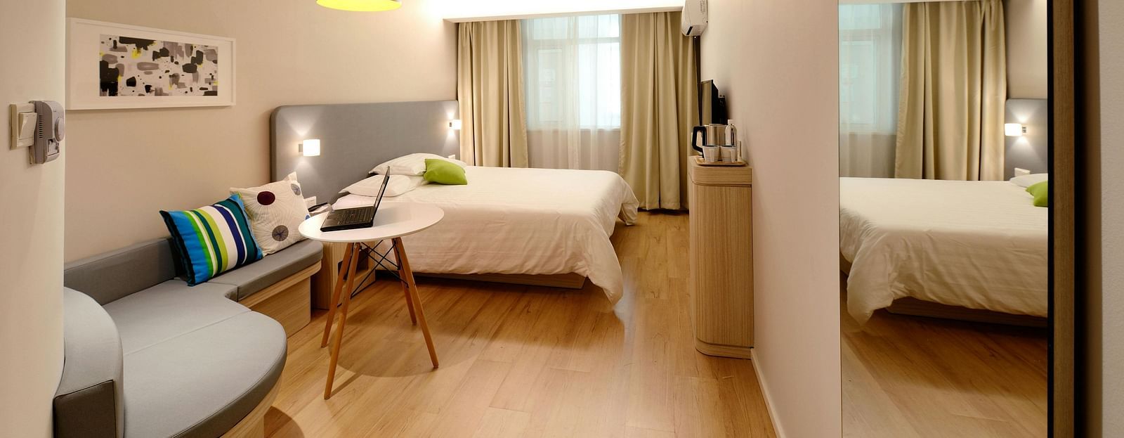 A image of a room with a comfortable bed, ambient lighting, cosy furniture and a television for entertainment