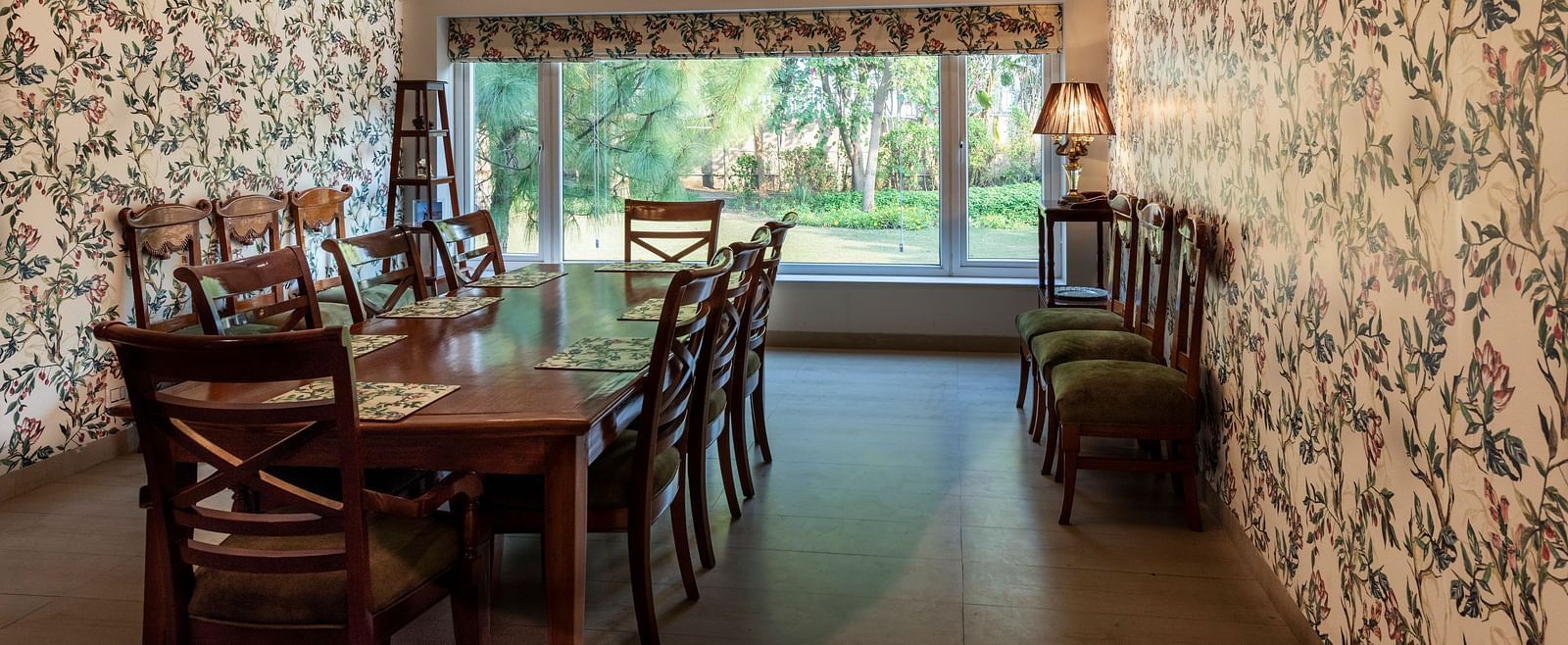 An image of a dining room with floral walls, a chandelier and an AC in the background.