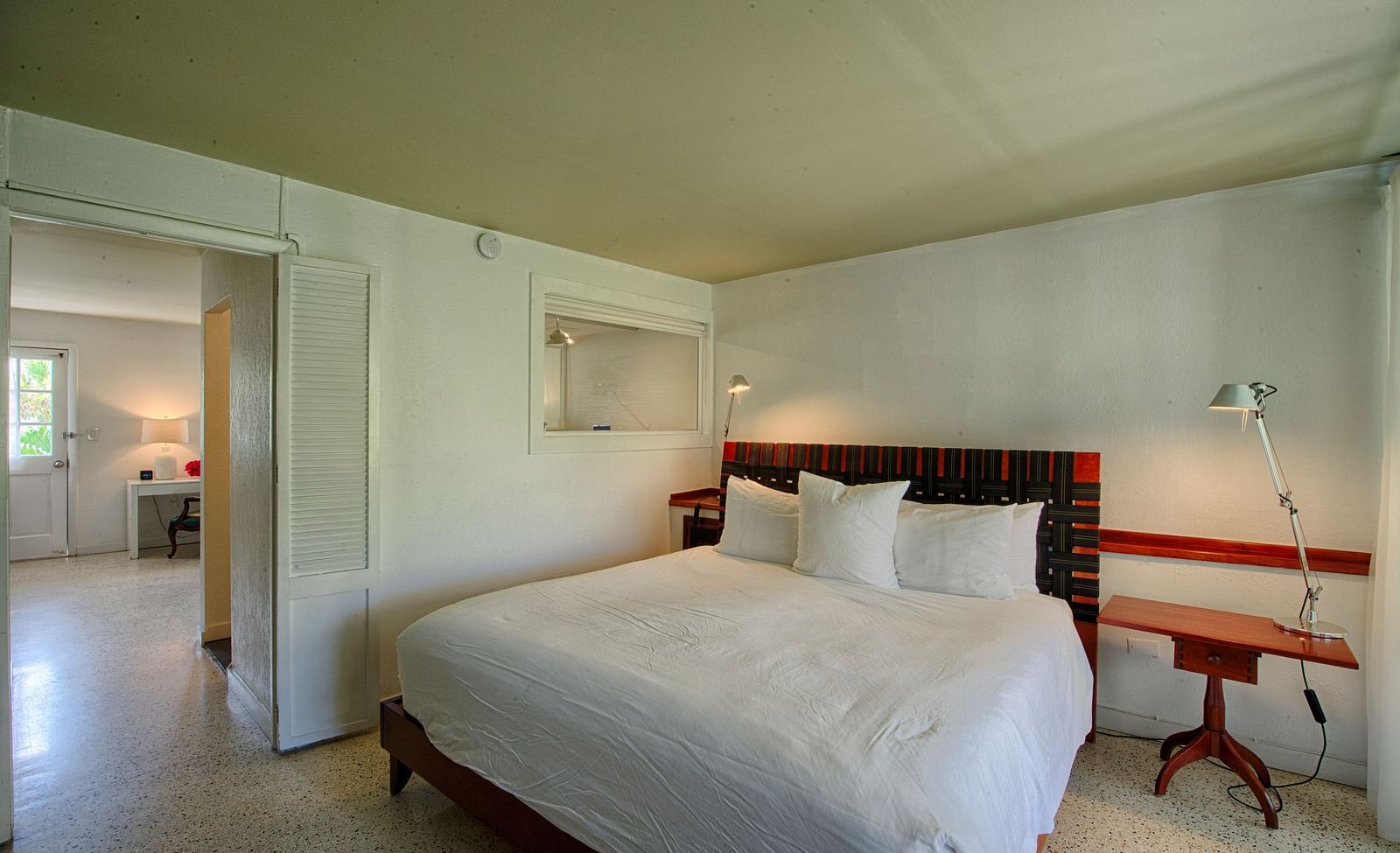 Spacious room at Casa Morada with a white bed, wooden headboard, and sitting area.