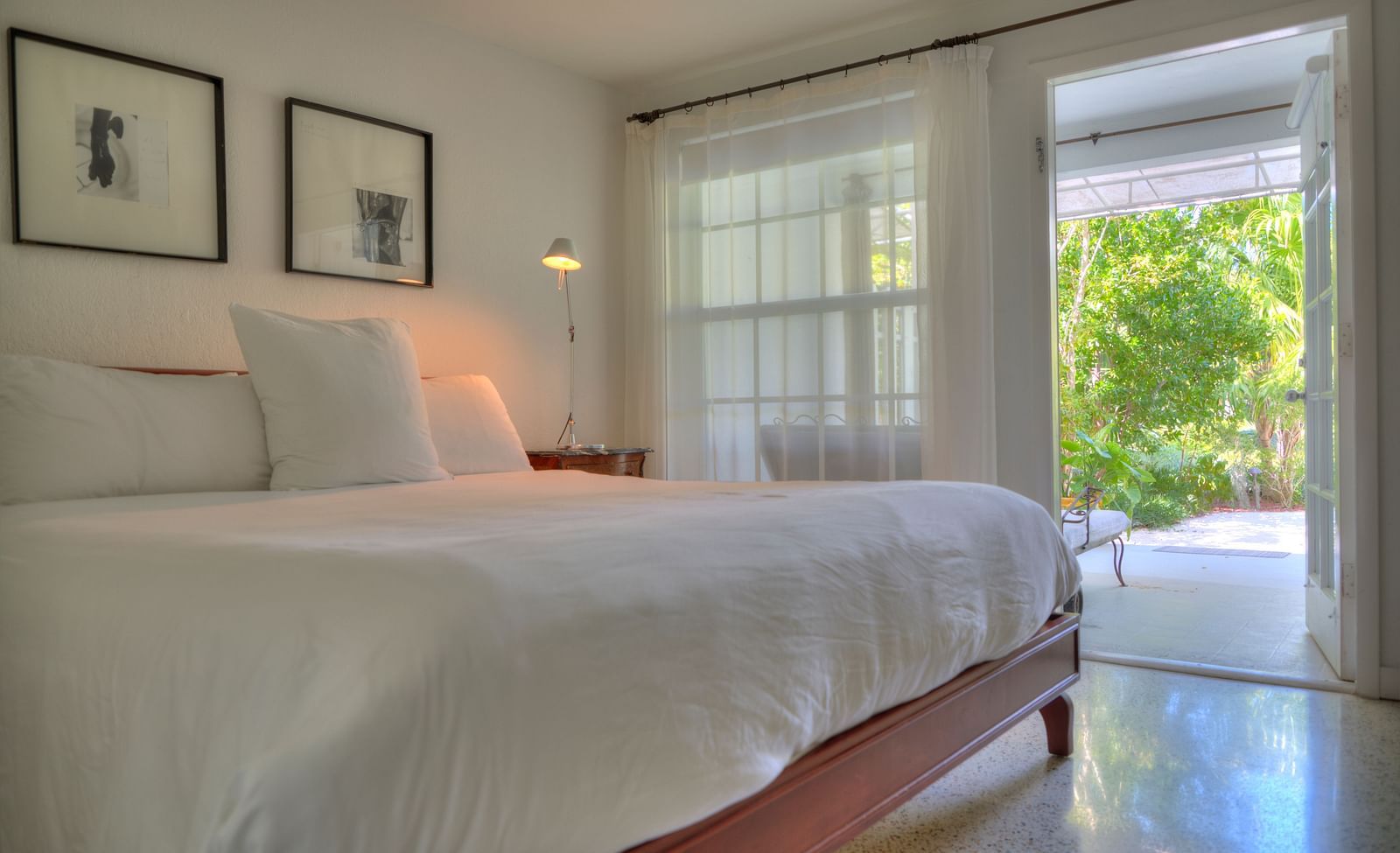 a spacious bedroom with a huge bed and a door leading to the garden at Casa Morada.