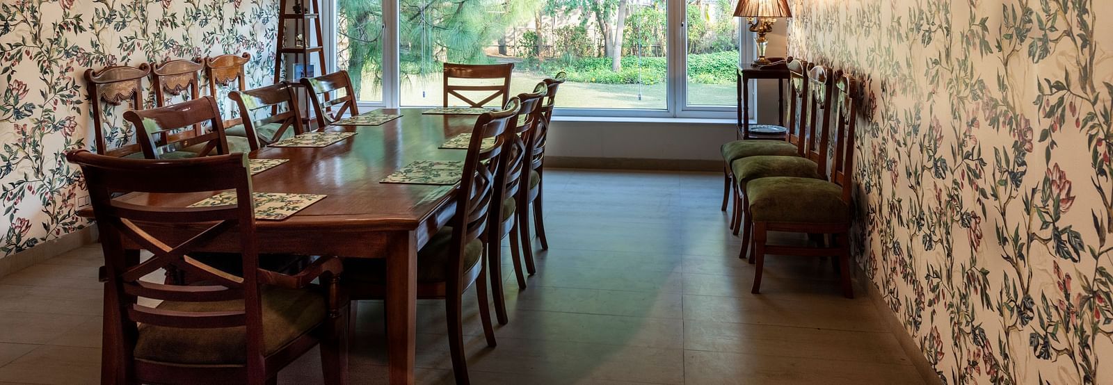 An image of a dining room with floral walls, a chandelier and an AC in the background.