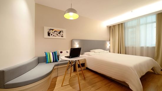 an image of a side view of a bedroom with a seating area