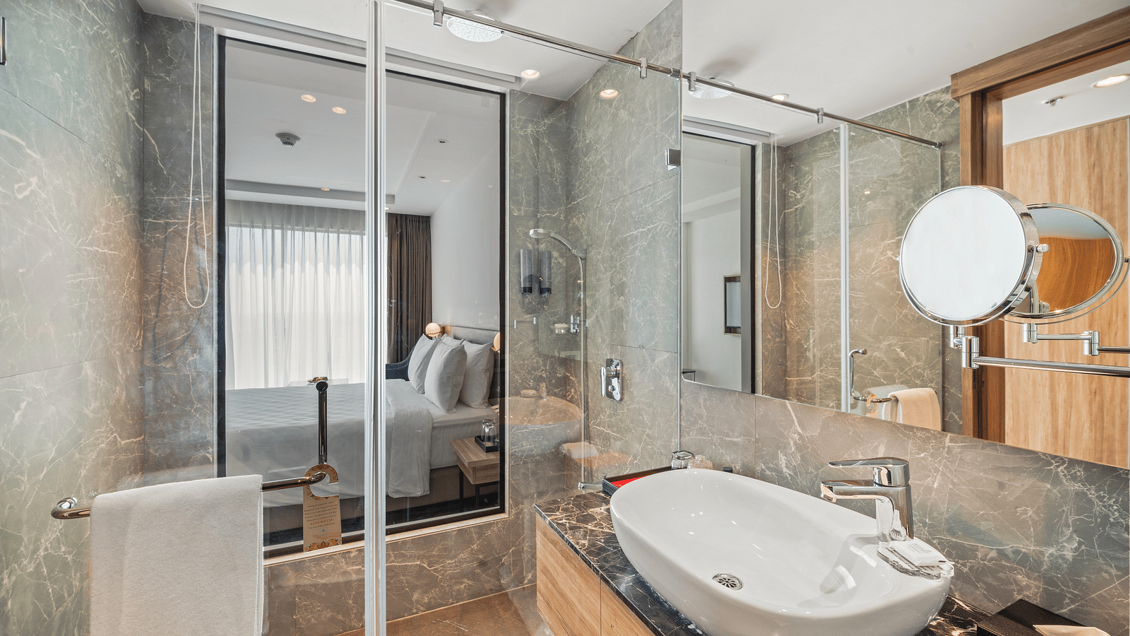 An image of a bathroom with a large sink, a shower cubicle and a shaving mirror - Grand Vijaywada by GRT Hotels