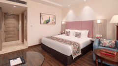 A hotel bedroom with a bed, a seating area